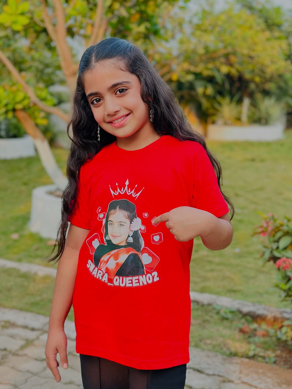 Girl wearing personalized red t-shirt with photo, crown, and Instagram name SWARA_QUEEN