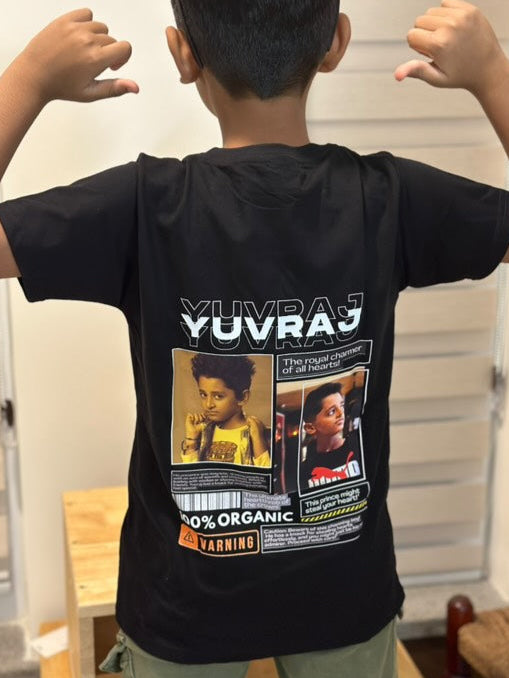 A child wearing a black personalized t-shirt with custom text and photo prints on the back.